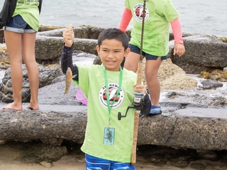 boy holding up fish